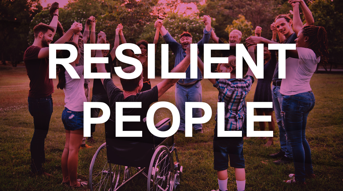 A diverse group of people standing outdoors in a circle with raised arms.