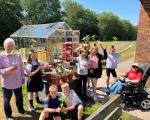 School children with two retirement housing residents planting greenery