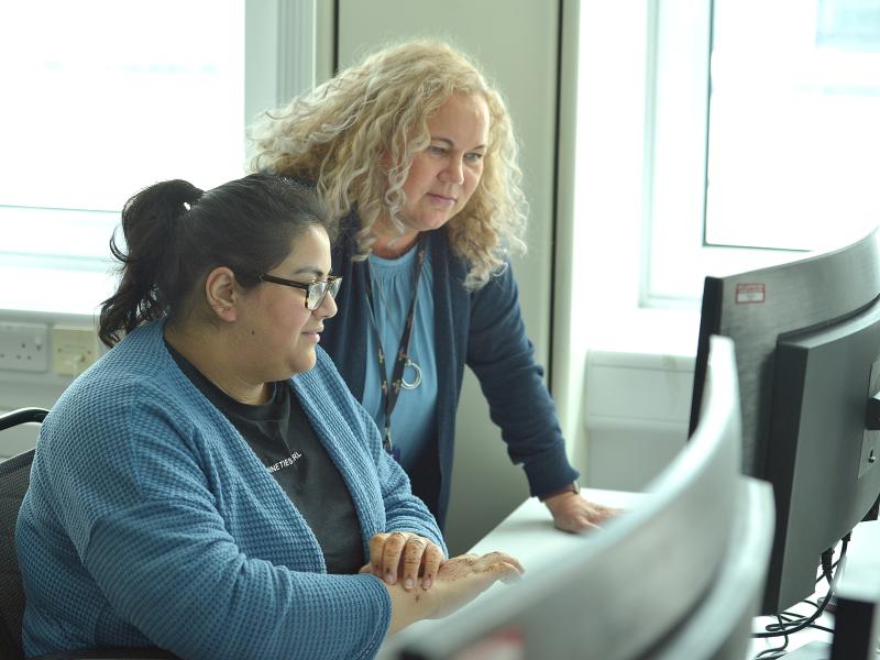 Summer Placement Student working on device with manager.