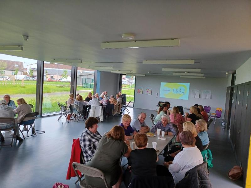 people sitting round tables talking in a hall