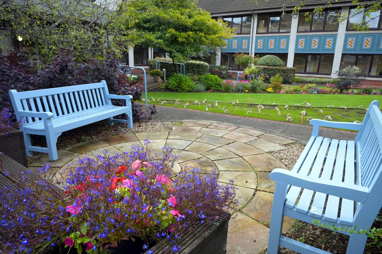 Colourful benches next to pots of flowers