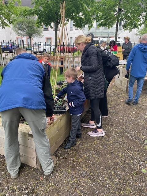 adults and children filling flower beds