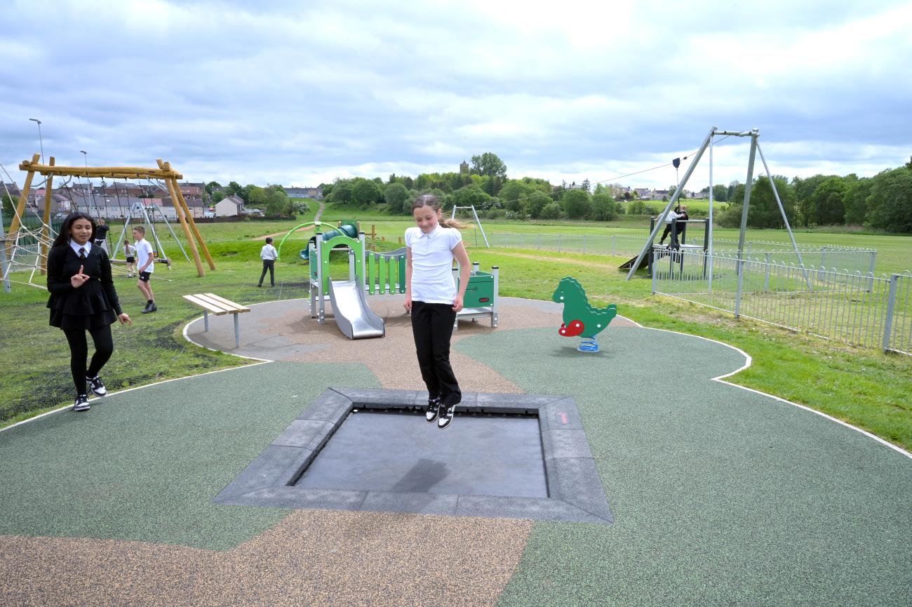 child playing on trampoline in play area