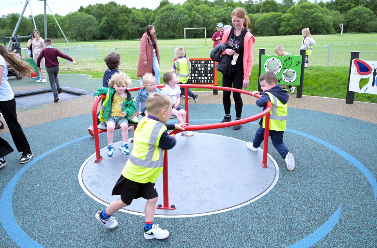children playing on roundabout in play area