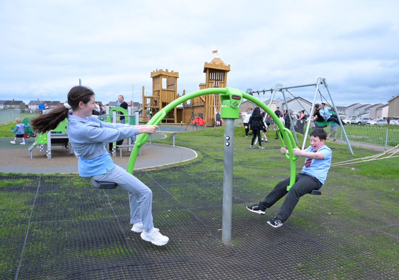 two children playing on seesaw in play area