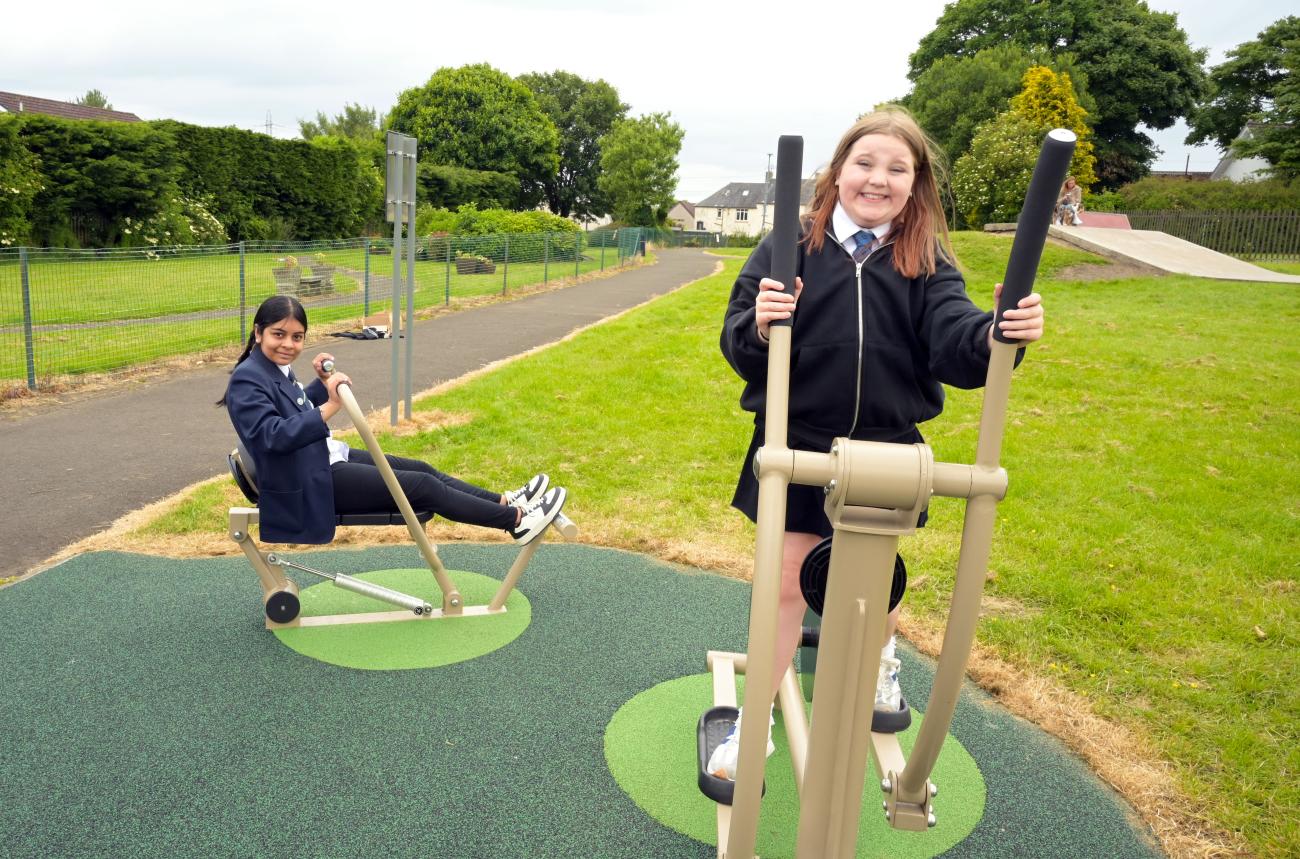 two children playing on outdoor gym equipment