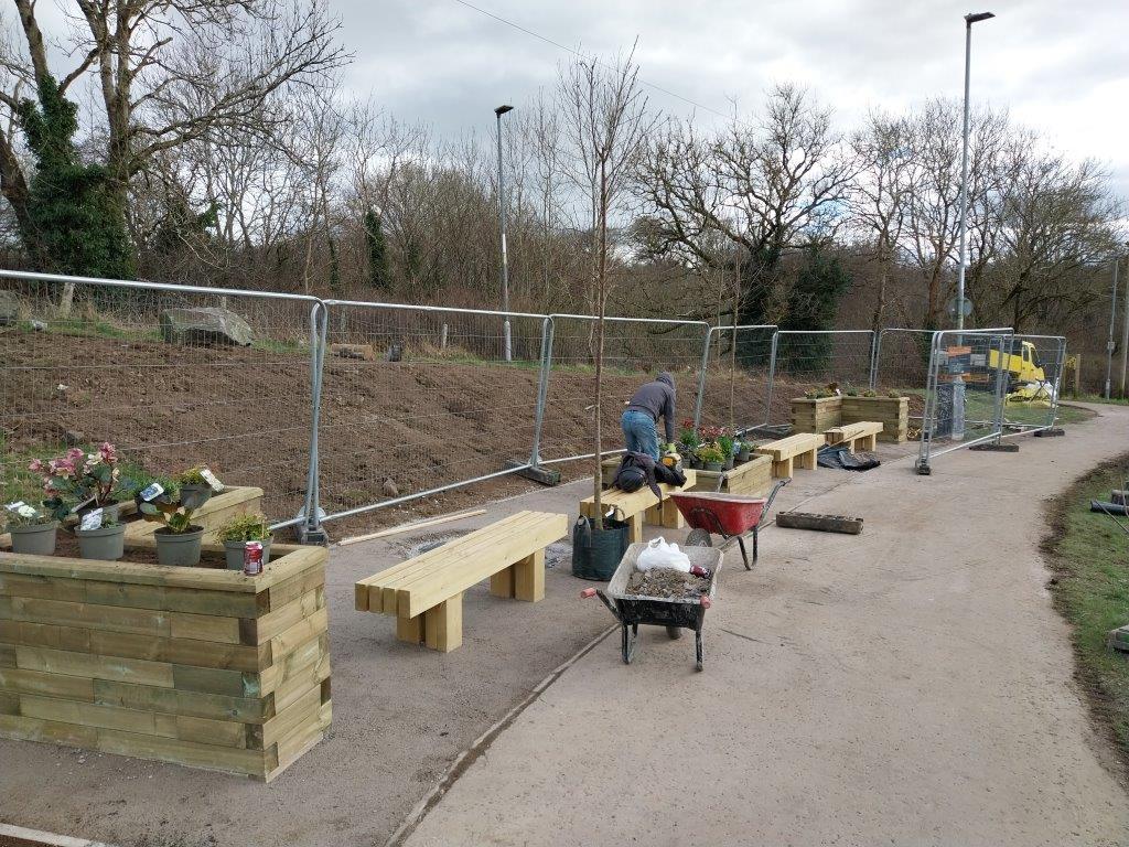In progress landscape image of community benches and planters. 