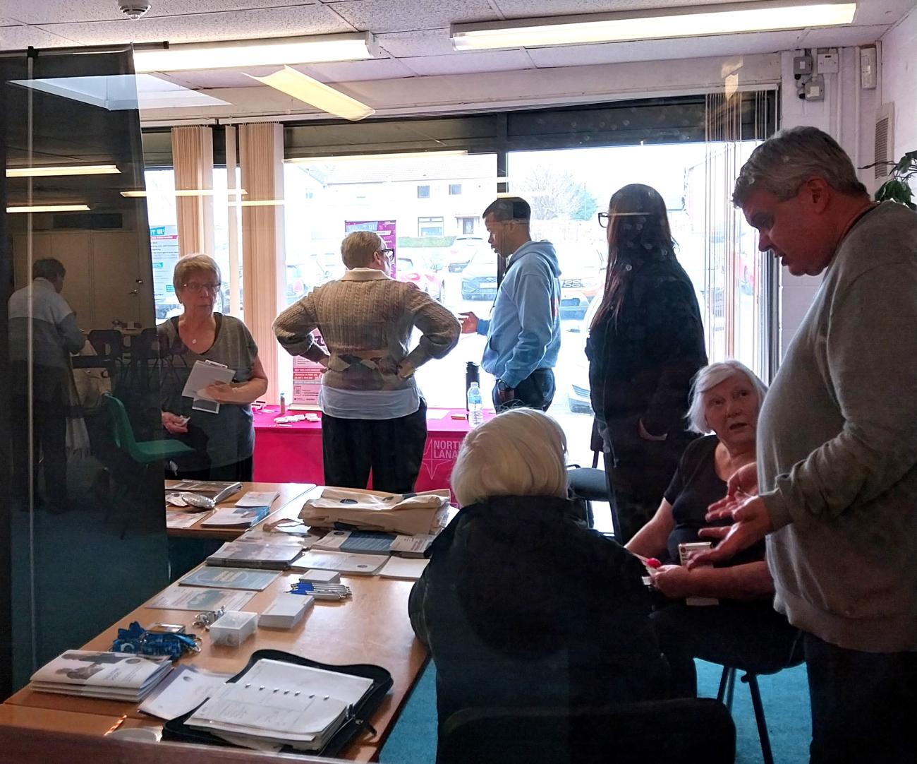 Community members engaging with information stall
