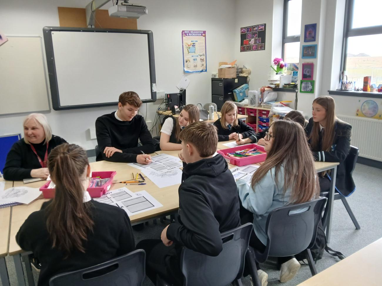 Students gathered around a table having a discussion 