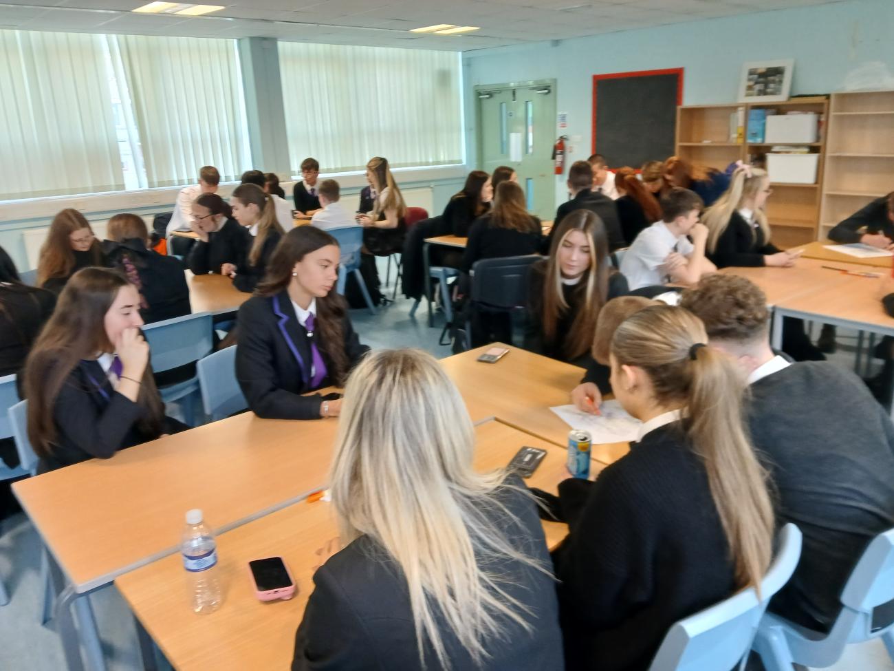 Students gathered around a table having a discussion 