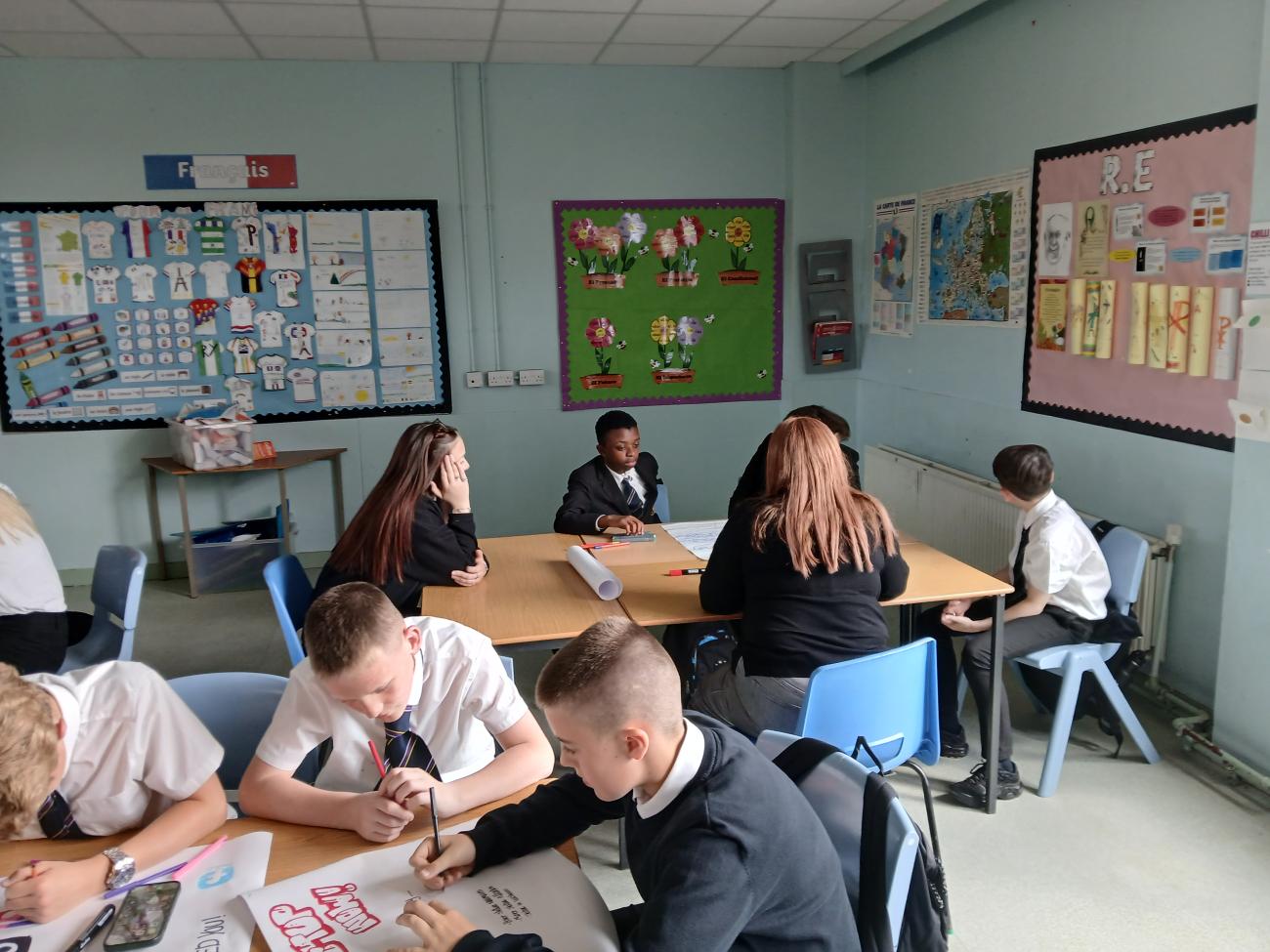 Students gathered around a table having a discussion 
