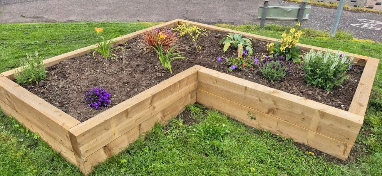 Small L Shaped Planter with soil and plants. 