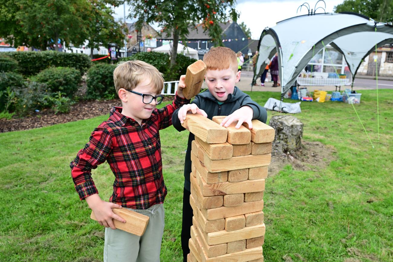 Children playing garden games - grass game of Jenga