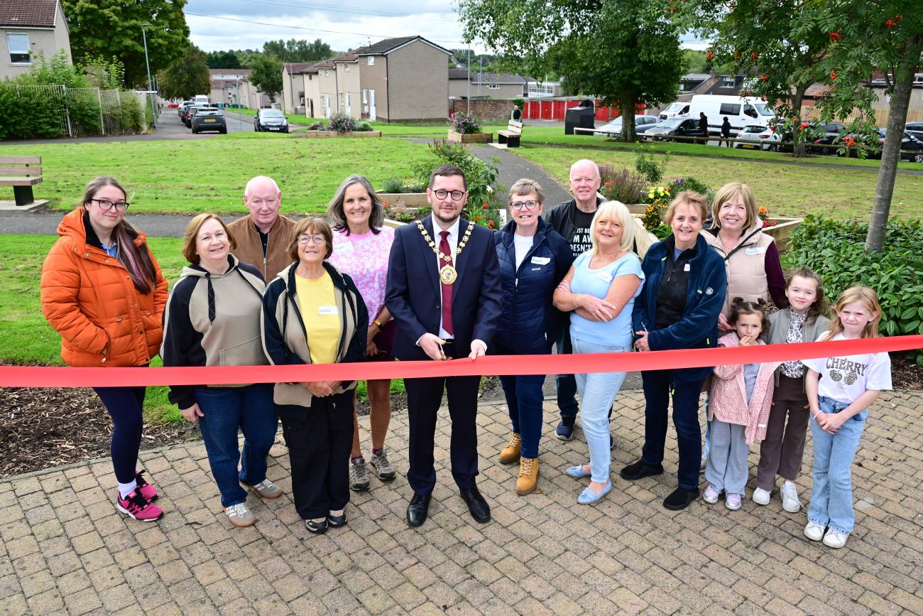 Ribbon cutting with community members and provost celebrating the opening of the garden