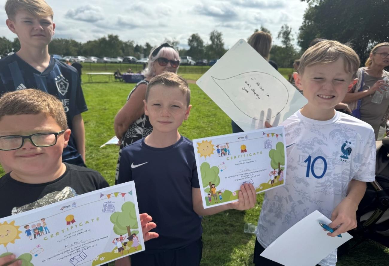 Children smiling showing of scavenger hunt certificates 