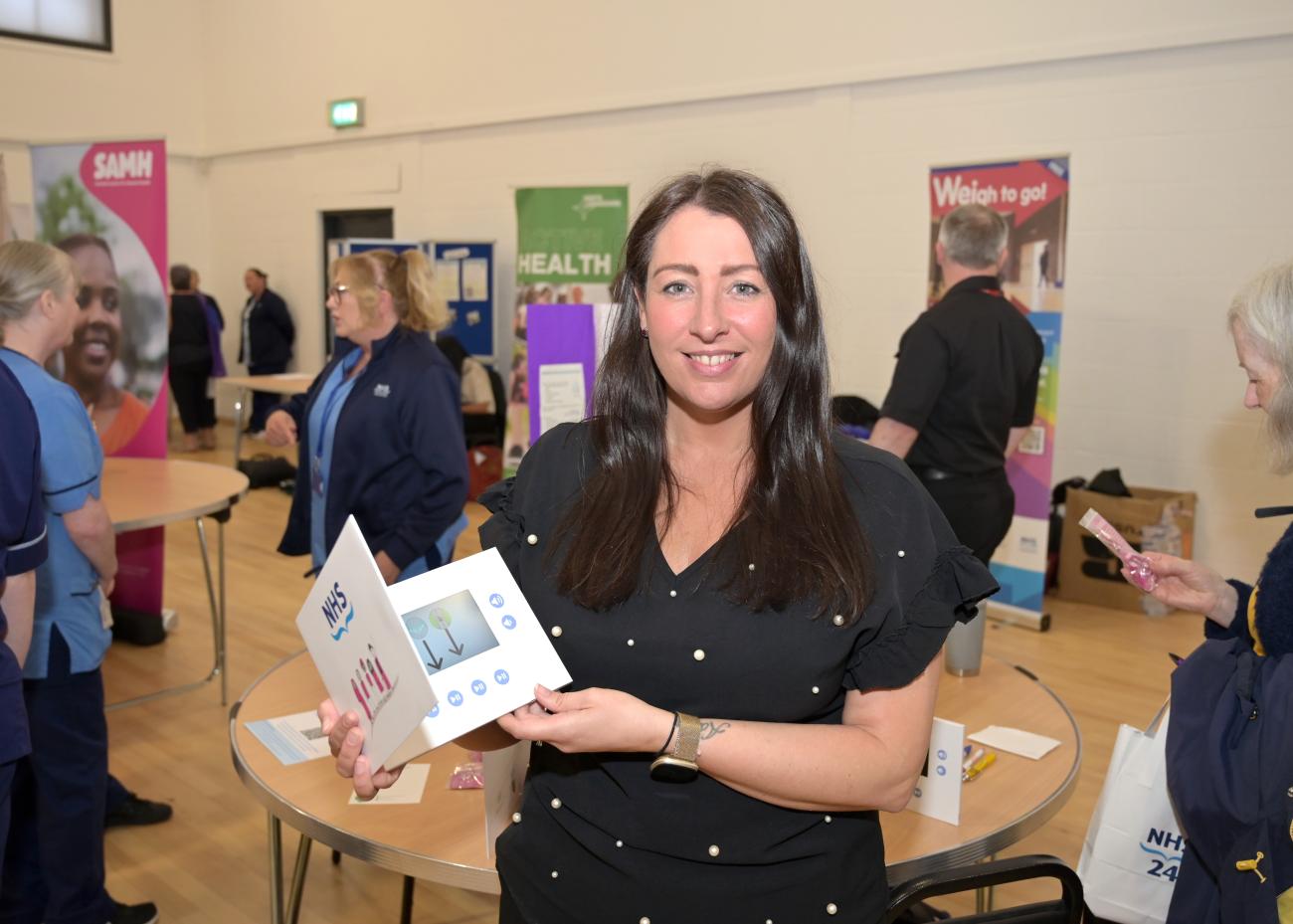 woman posing for picture holding a leaflet 