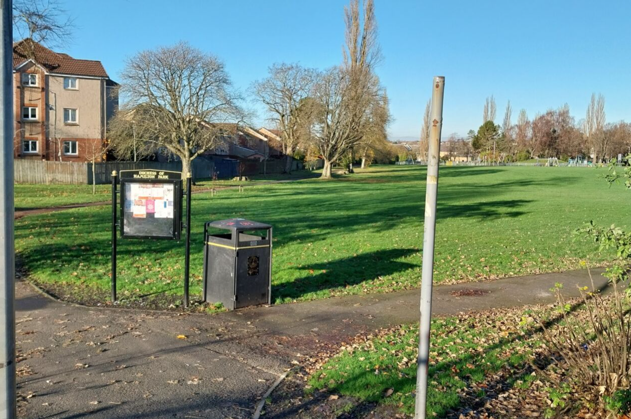 Walkway through park highlighting community noticeboard