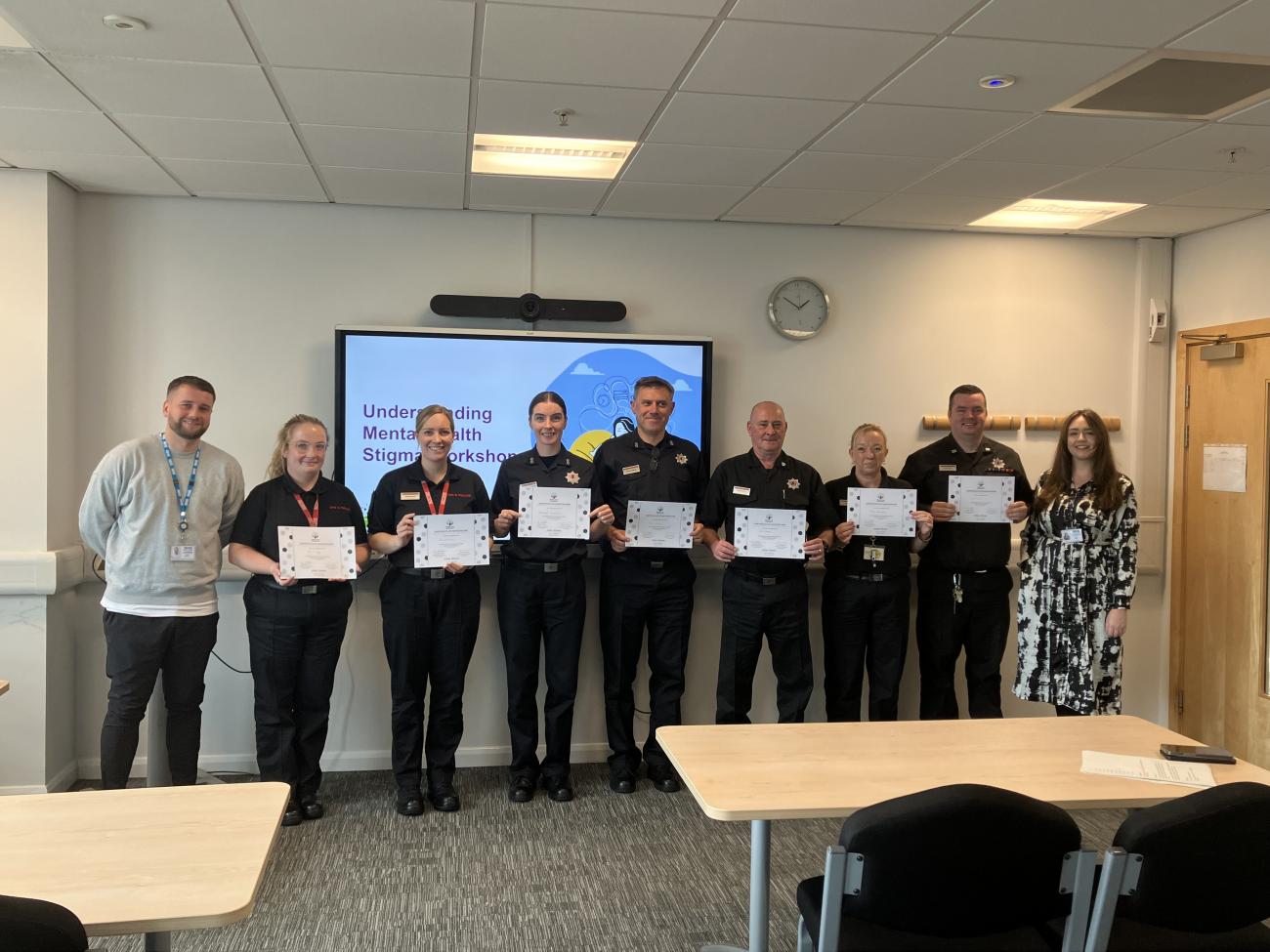 Group of people standing holding certificates posing for photo