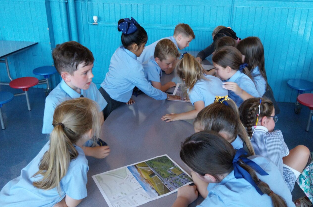 Children around a table picking ideas for a local play park 