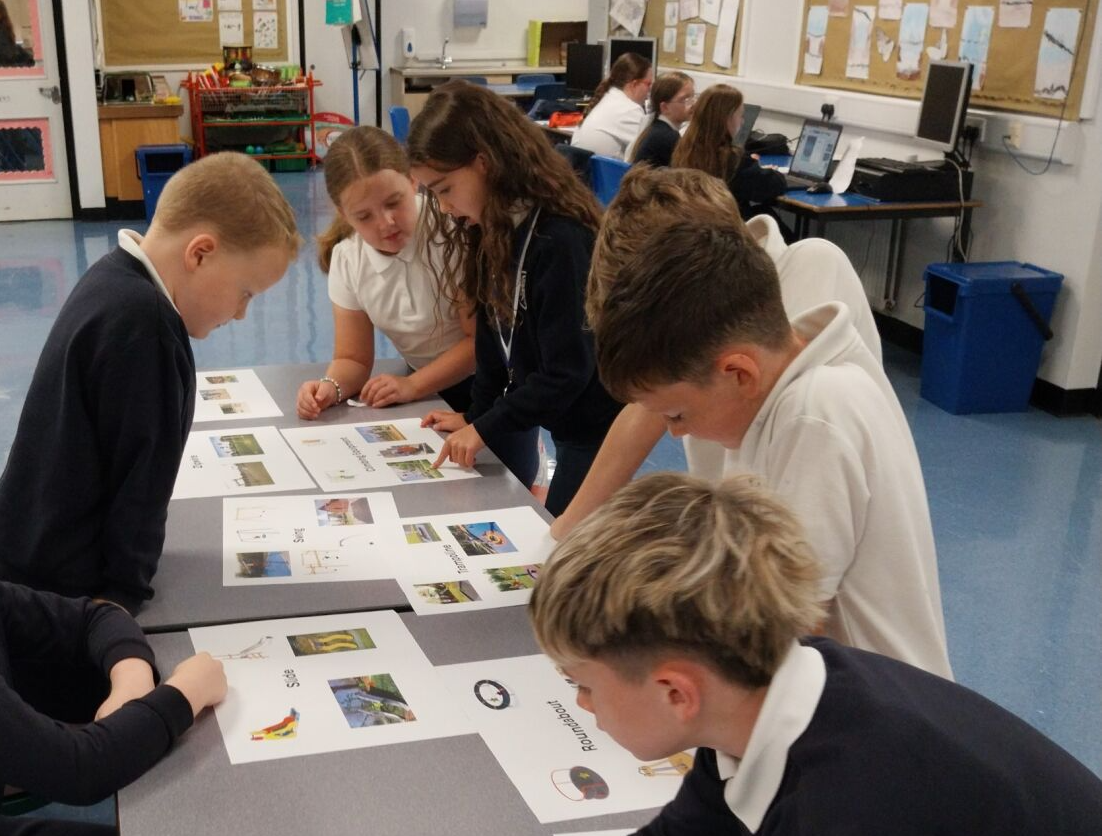 Children around a table picking ideas for a local play park 