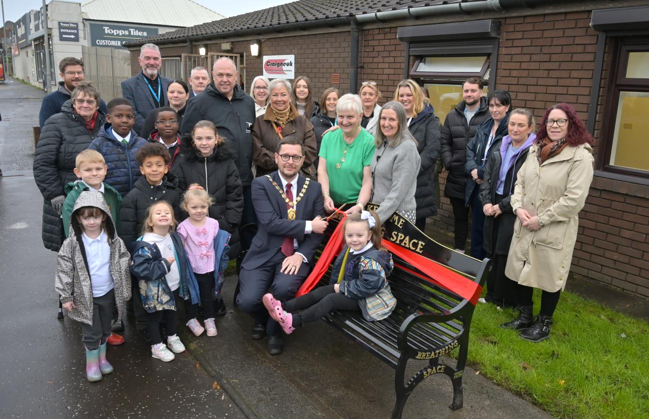 Council Provost and community/council members posing for picture around bench