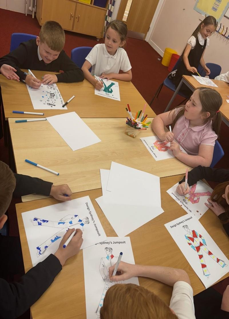 Pupils sat around a desk colouring and designing outfits