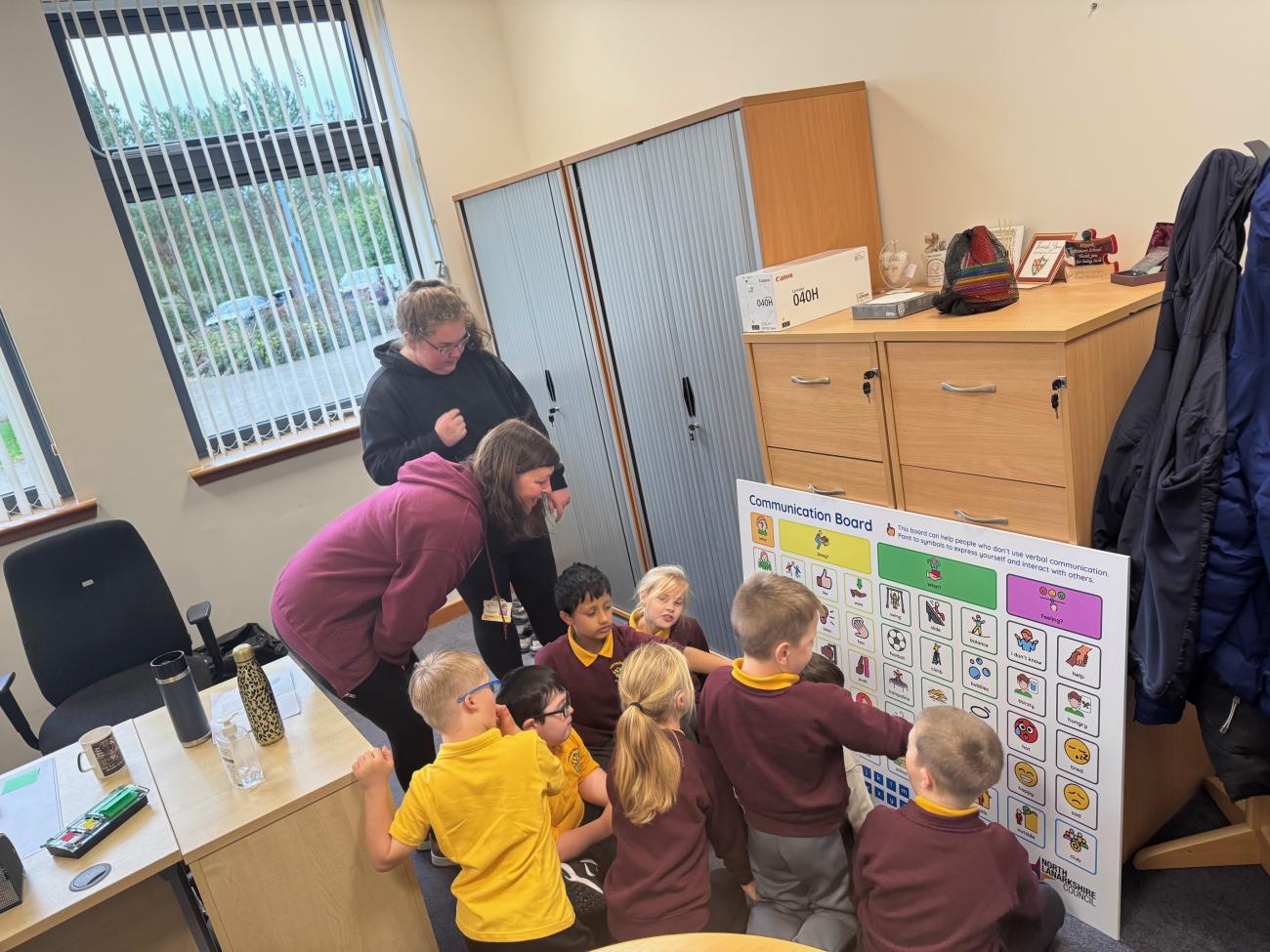 Pupils of Firpark Primary School interacting with teacher and communication board