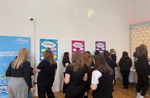 Students and teachers in a room looking around at community empowerment posters