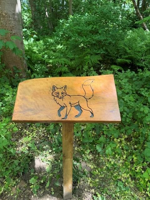 Carved nature sign depicting local foxes