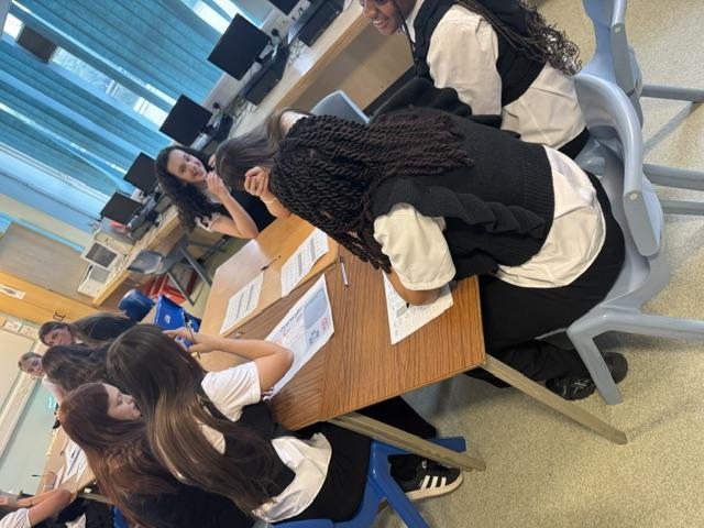 School pupils sitting at desk completing a survey