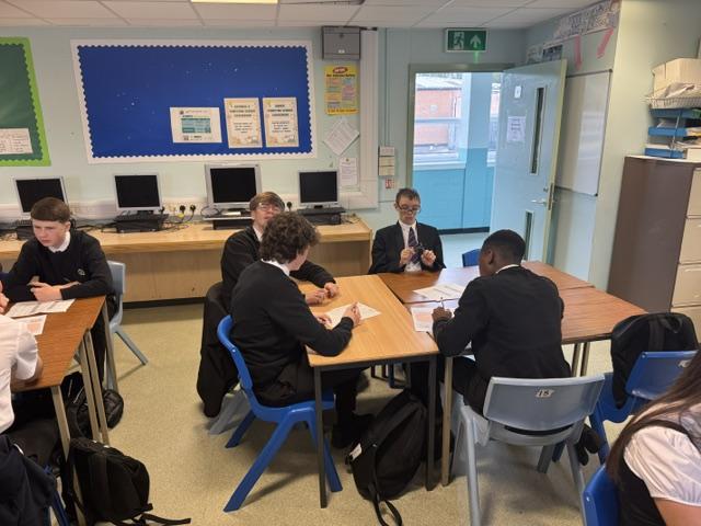 Pupils sitting around a desk 
