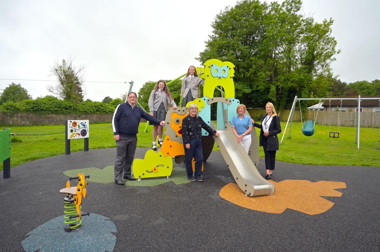 Playpark slide with people standing beside it.