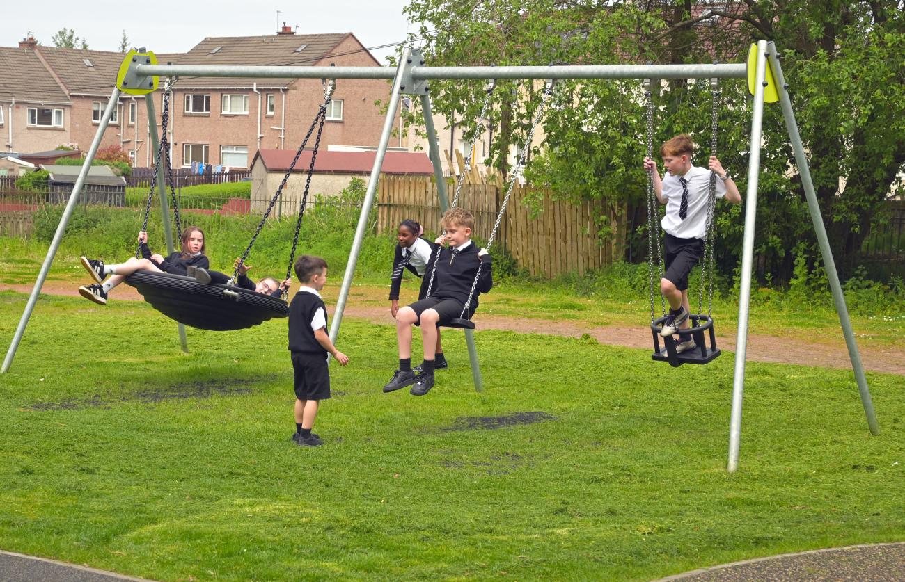 Pupils playing on new swing set at Waverly Drive Park