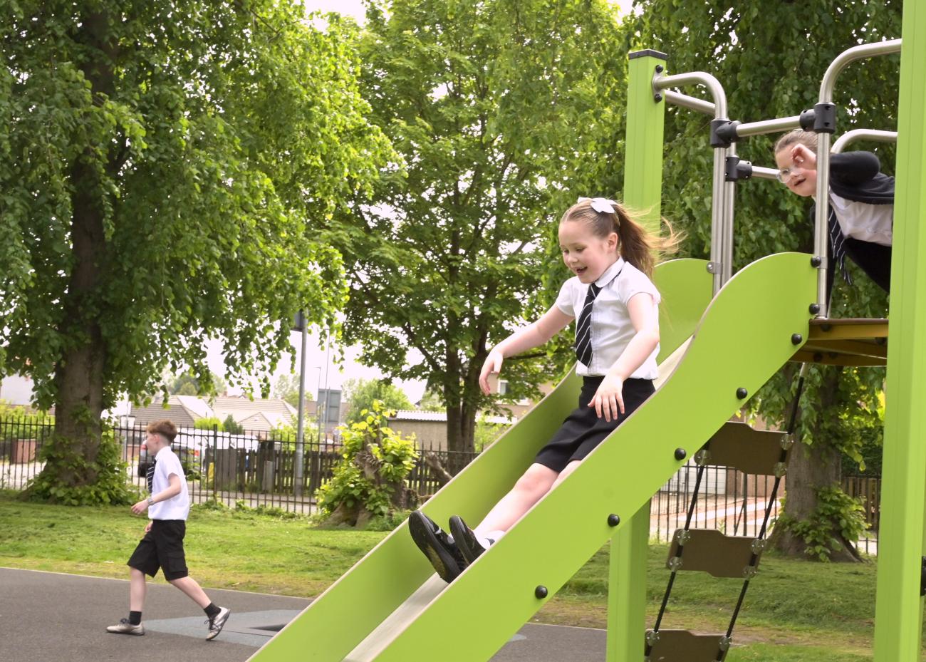 Pupils going down a new slide in Waverley Drive Park 