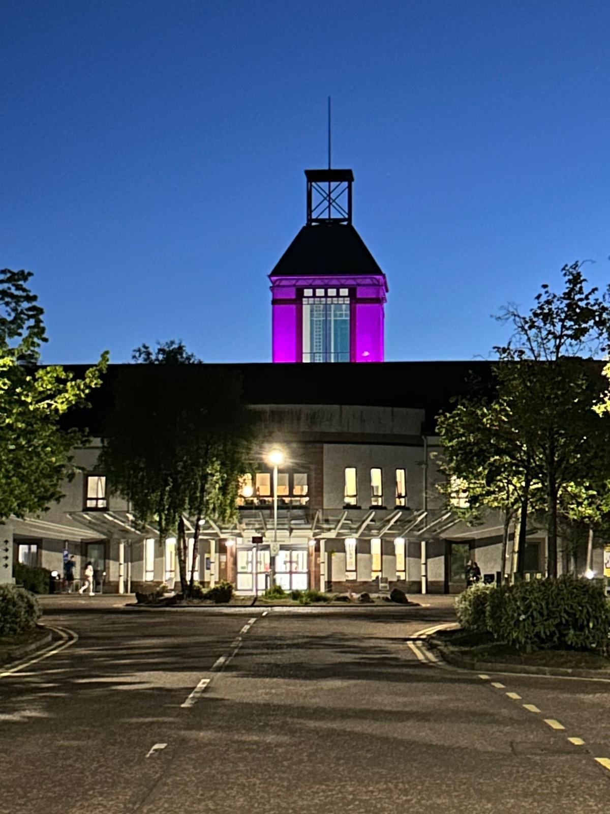 Wishaw Hospital with the spire lit up pink to support mental health week