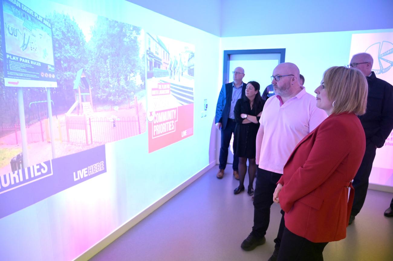 adults looking at walls which are projecting images