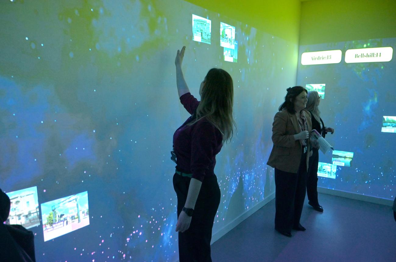 adult putting hand on wall to play interactive game