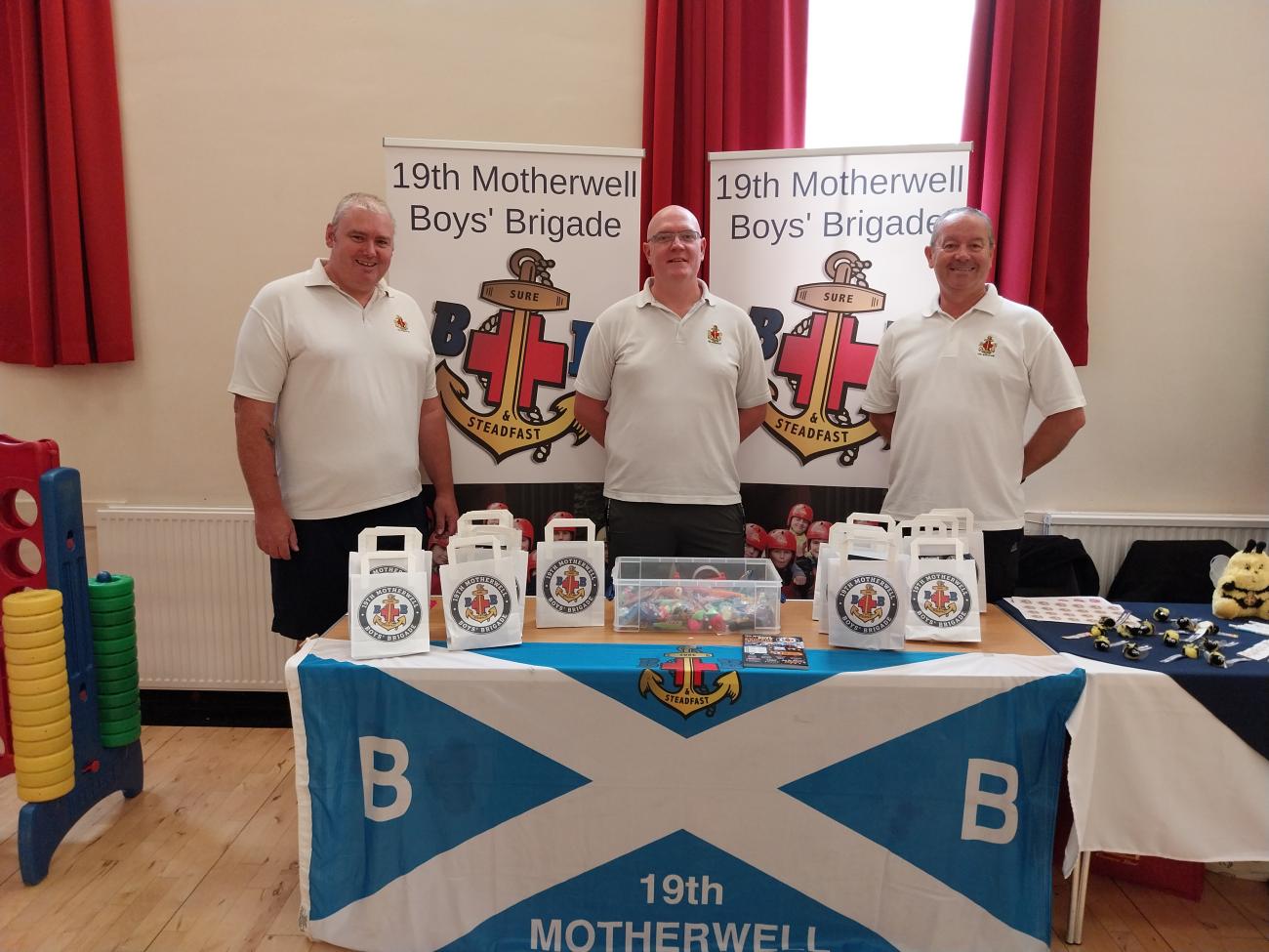 men standing around table with promotional materials