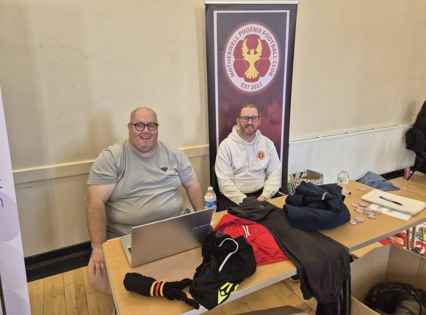 adults sitting at table with promotional materials