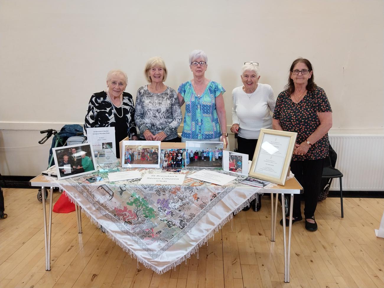 Women standing around table of promotional materials