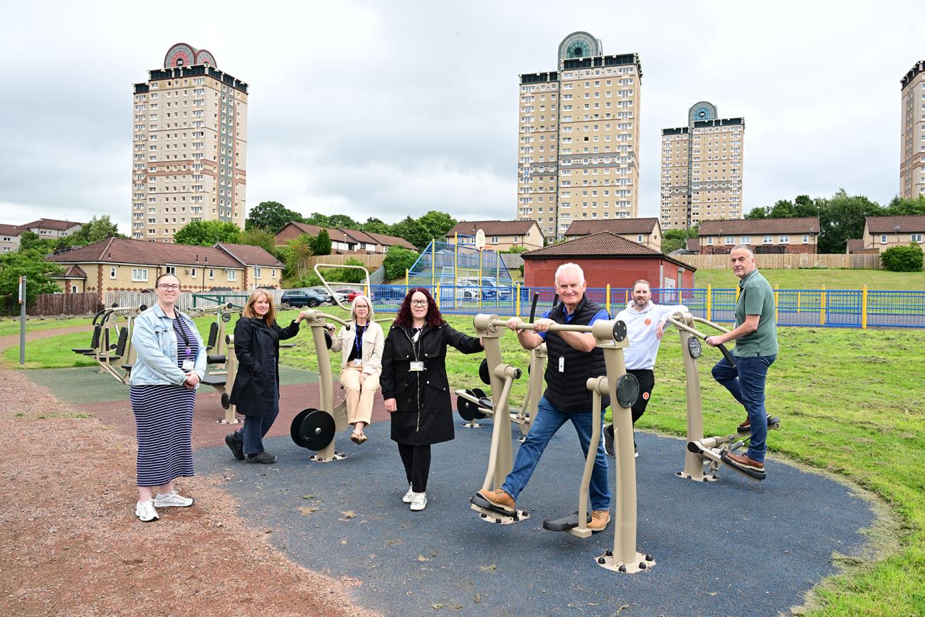 adults standing on and next to gym equipment