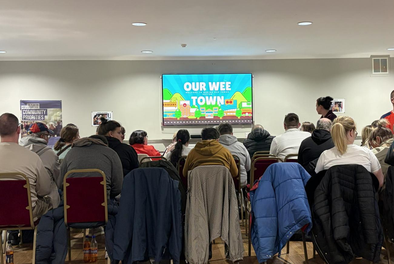 people sitting looking at tv screen with presentation