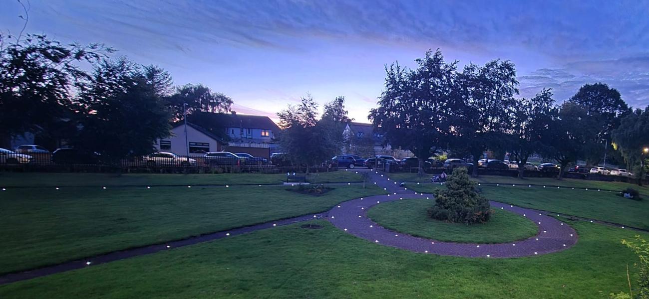 park during during dusk with lights around pathway